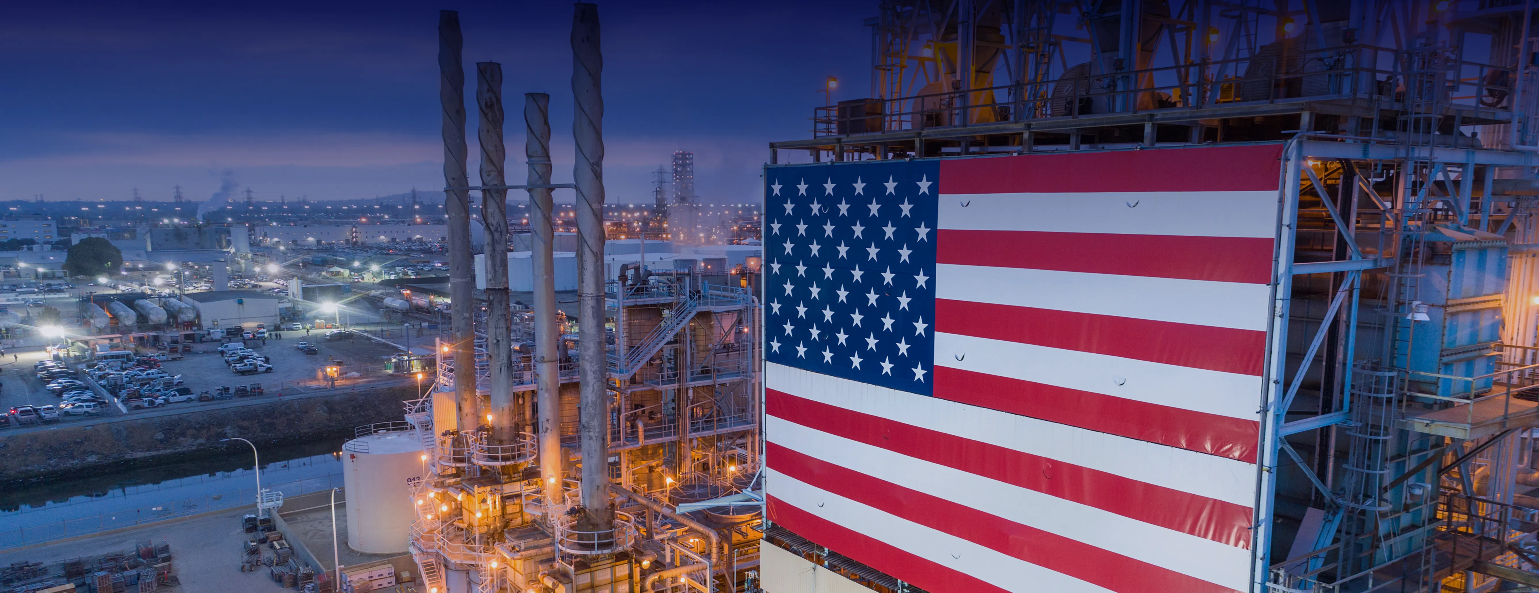 Nagliliwanag sa gabi ang Los Angeles Refinery ng Marathon, kung saan kitang-kita ang watawat ng America