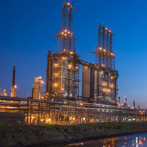 Ang mga Coker unit sa Los Angeles Refinery ng Marathon ay naliliwanagang mabuti sa gitna ng madilim na kalangitan