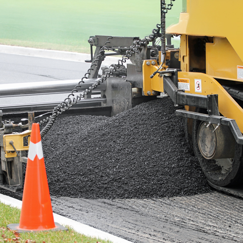 Xe rải nhựa đường đang rải một lớp nhựa đường mới. Xe rải nhựa đường đang rải một lớp nhựa đường mới.